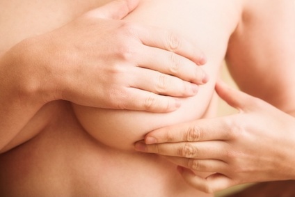 Woman examining her breast for signs of breast cancer